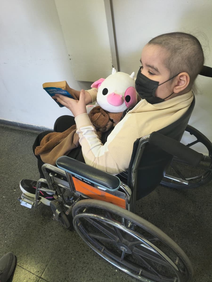 Manu leyendo, abrazada a sus peluches